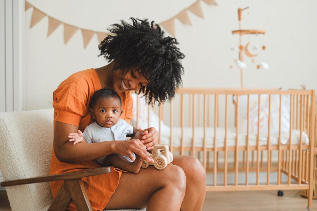 Joyful mother and her baby enjoy playtime in a cozy nursery setting, creating a warm family moment.